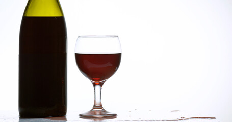 Red Wine being poured into Glass, against White Background