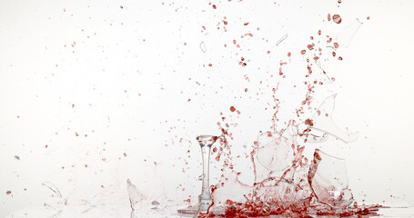 Glass of Red Wine Breaking and Splashing against White Background