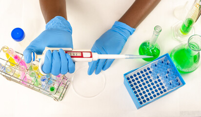 A close up of female hands holding a micropipette showing the different measurements with lab...