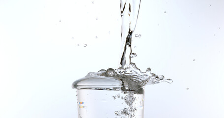 Water being poured into Glass against White Background
