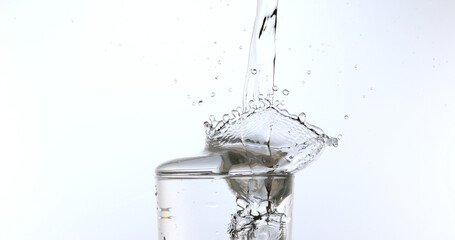 Water being poured into Glass against White Background