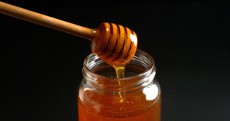 Honey Flowing in a spoon against Black Background