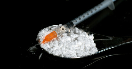 Siringa with Powder Drug against Black Background