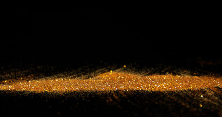 Gold Powder falling against Black Background