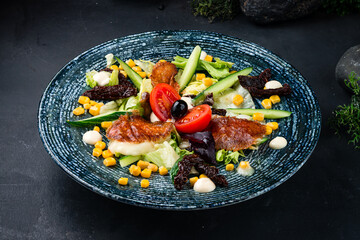 Salad with fried suluguni cheese, sun-dried tomatoes, corn, cucumbers, lettuce and sauce in a plate.