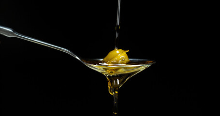 Green Olive, Olea europaea, Falling in a Spoon against Black Background - Powered by Adobe