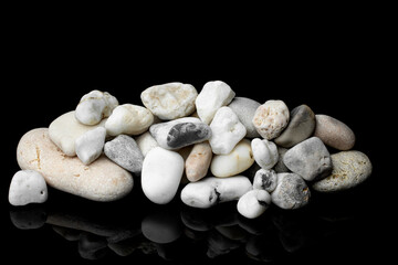 Fototapeta na wymiar A group of white and gray pebbles isolated on a black background.