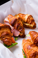 Set of fresh croissants with ham, cheddar cheese, lettuce, salmon, cucumber, cream cheese, pear and cinnamon.