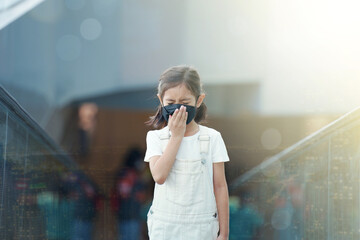 A girl wearing a mask, Children's health and urban pollution.