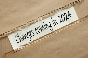 Changes coming in 2024 text on white paper. torn craft paper