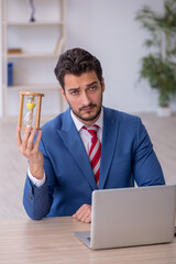 Young male employee in time management concept