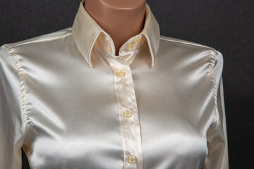 Satin and silk women shirt with mother-of-pearl buttons on a dark background. Style and fashion in clothes. Textile industry.