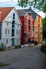 Street with old wooden houses and flags in the city of Trondheim, Norway.