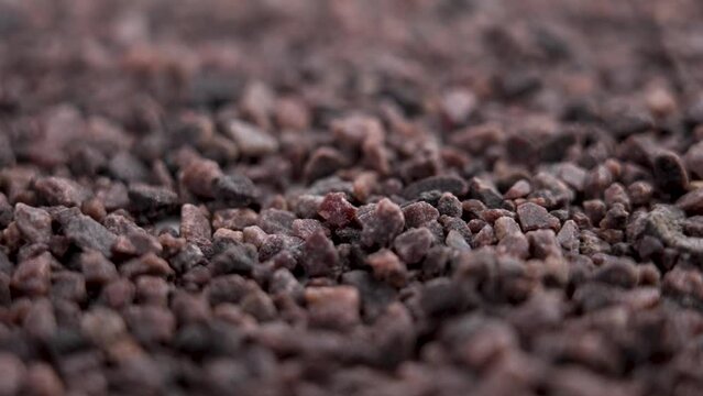 Ayurvedic black Himalayan salt with kiln-fired dark crystals falling in slow motion with rotation
