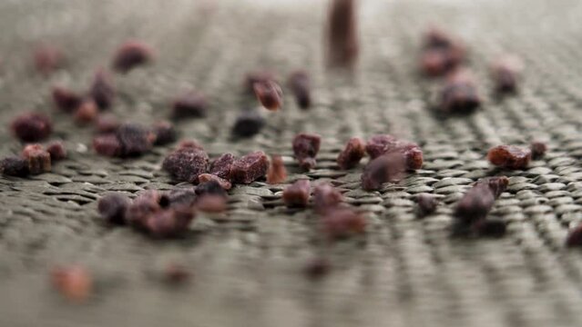 Black Kala Namak Himalayan salt. Falling dark fired crystals on a rough surface in slow motion. Rotation. Macro shot