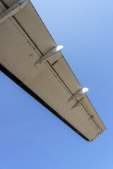 Detail of old propeller plane, wing with blue sky background