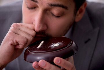 Young male drug addicted employee at workplace