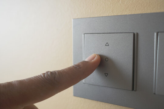 A finger turning on lighting switch .