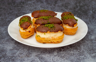Eclairs with chocolate topping on serving plate