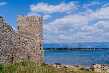 Fototapeta na wymiar Old Venetian fort. ruins of an old medieval castle on the mediterranean sea. Kastelina castle, fortress ruins on Vir island, Croatia, Europe.