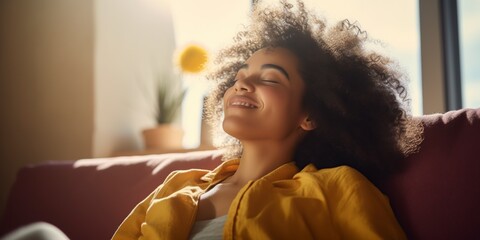happy african american woman relaxing on sofa at home