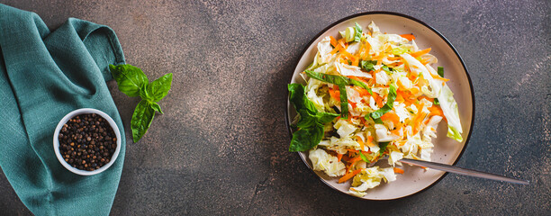 Salad cole slaw with fresh cabbage, carrots and basil on a plate top view web banner