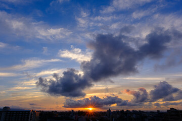 兵庫県神戸市東灘区の高層マンションの上層階からの夜明け。大阪生駒山から太陽が昇り、あたりはオレンジ色に染まり、ビル群がシルエットで浮かぶ