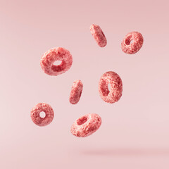 Fototapeta premium Tasty pink ring Cereals falling in the air isolated