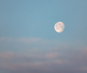 Lonely bright moon in the morning cloudy blue sky, moonlit morning in the desert
