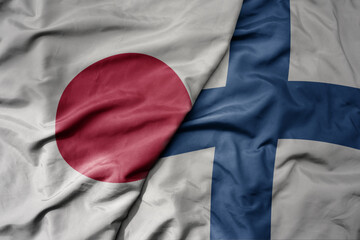 big waving national colorful flag of japan and national flag of finland .