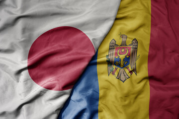 big waving national colorful flag of japan and national flag of moldova .