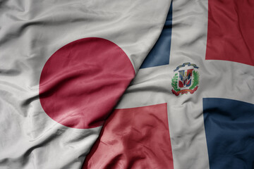 big waving national colorful flag of japan and national flag of dominican republic .