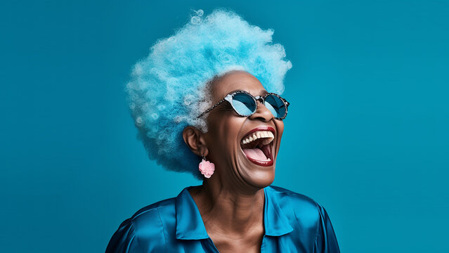 Happy, laughing, lovely old woman, with blue afro hair and blue sunglasses, on solid colour background, with room for text.