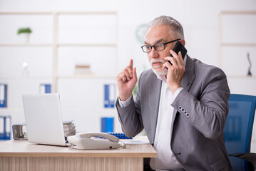 Old male employee working in the office