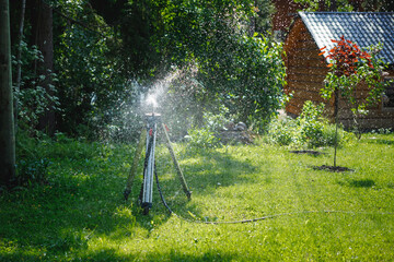 garden sprinkler on a tripod watering new lawn