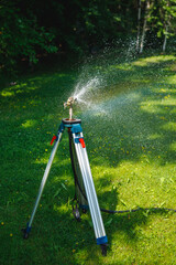 garden sprinkler on a tripod watering new lawn