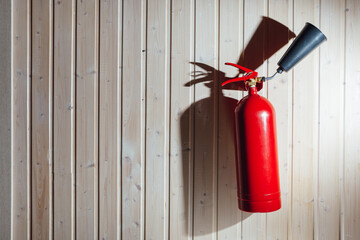 fire extinguisher on wooden deal board wall with copy-space