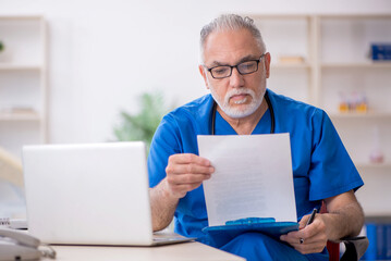 Old male doctor working in the clinic