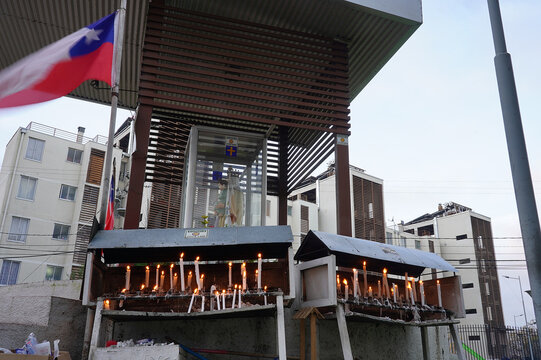 Candles in front of prayer place dedicated to Saint ("Nuestra señora del carmen" = "our lady of Carmen") in the center of a small south american town (Talca, Chile)
