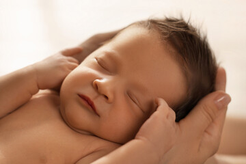 Fototapeta na wymiar Woman holding her sleeping newborn baby, closeup