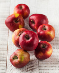 Ripe juicy red apples on a wooden white background. Harvesting.