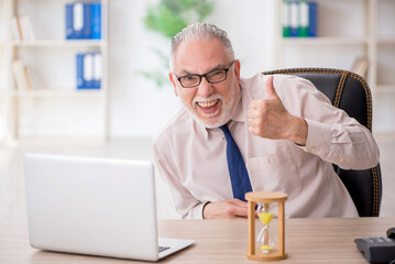 Old male employee in time management concept