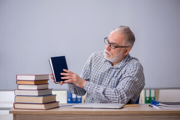 Old male teacher suggesting book