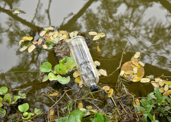 Disposable clear plastic bottles in natural water sources. Environmental pollution. Disposing of...