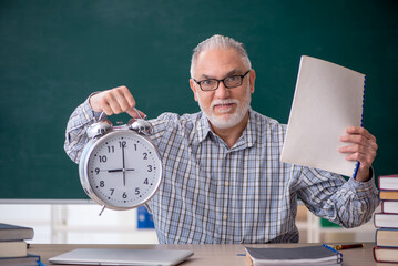 Old male teacher in time management concept