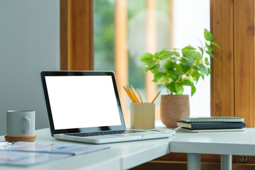 Computer laptop with empty display on wooden table in modern office.