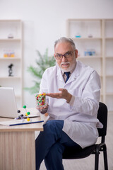 Old male doctor suggesting pills in the clinic