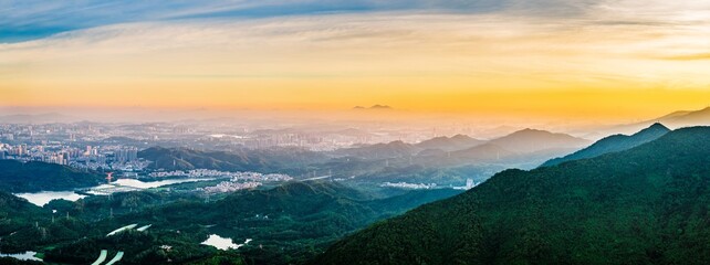 Green mountain and skyline with modern city buildings at sunrise in Shenzhen, Guangdong Province,...