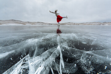 The Lady in a red skirt is doing ice skating on frozen Lake Baikal. Hills in the background. - Powered by Adobe