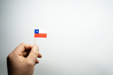 hand holding a chilean flag with white background